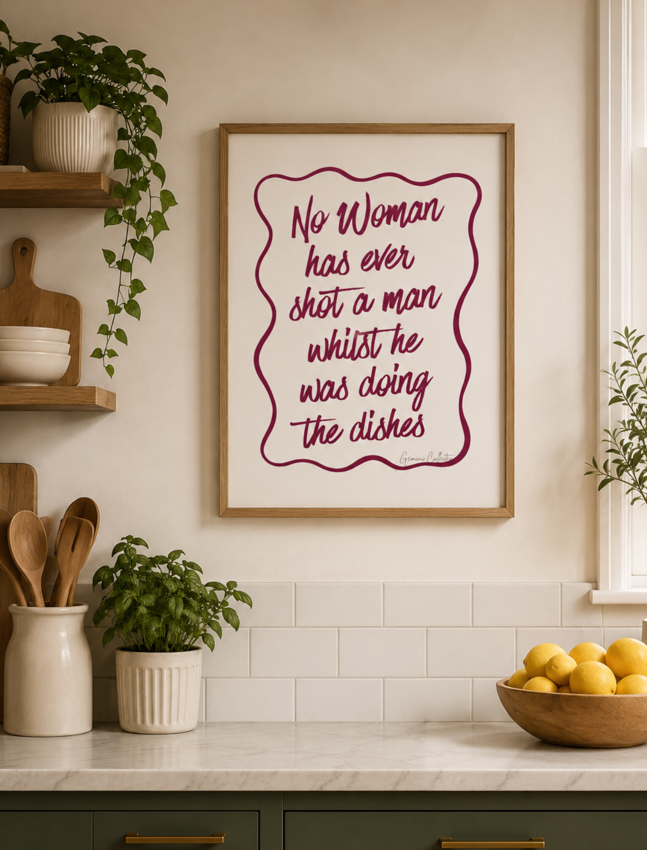 Kitchen interior with a framed humorous quote on the wall.