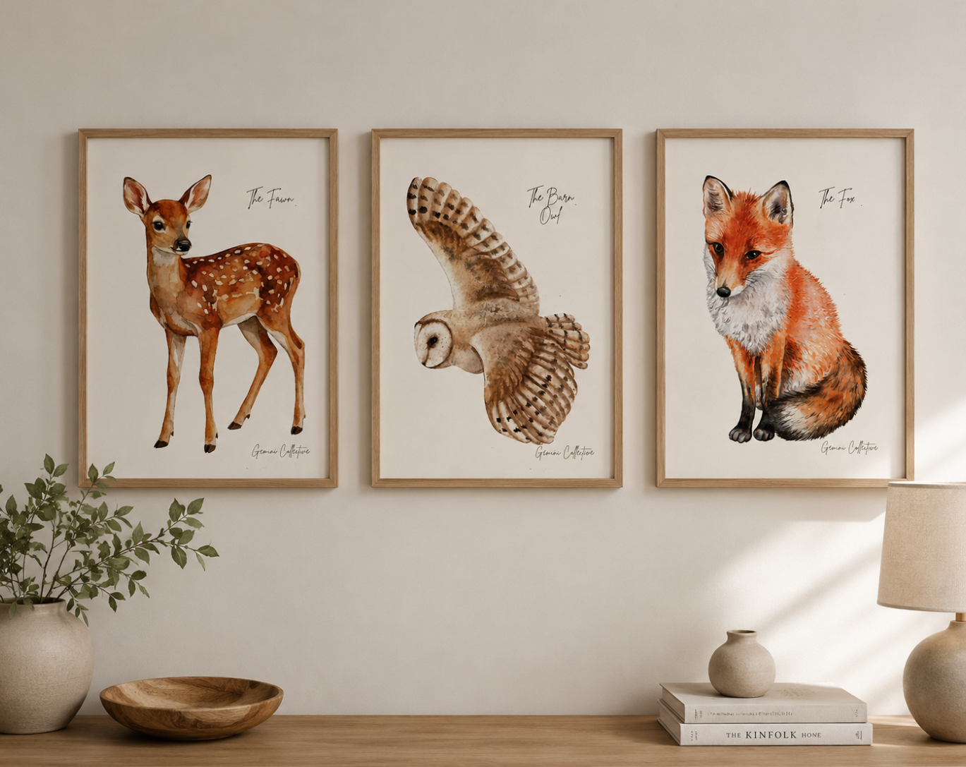 Three framed animal prints of a deer, owl, and fox on a wall above a wooden shelf.